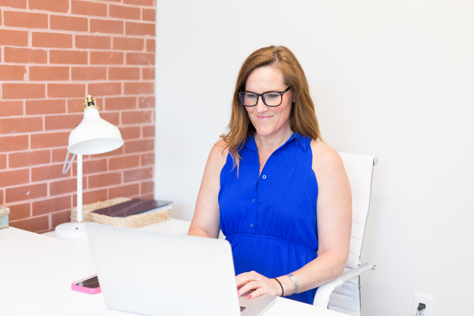 A woman working at a laptop in a bright office